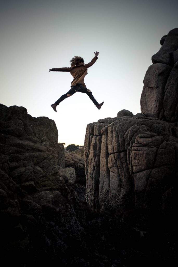Kid jumping over a rock ledge living life