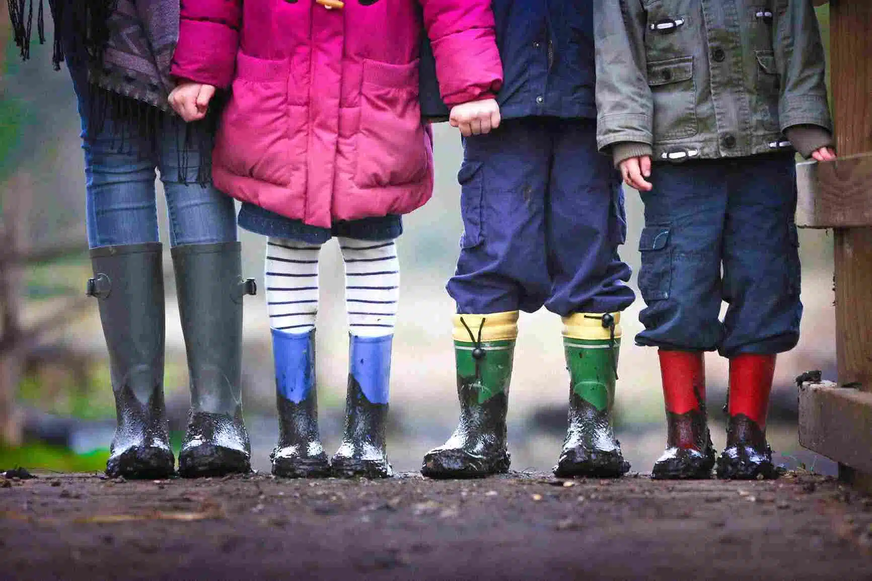 Four kids who have gum boots on and have played in the mud